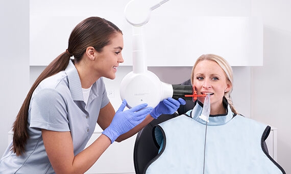 Hygienist positioning Heliodent Plus and Xios AE on patient